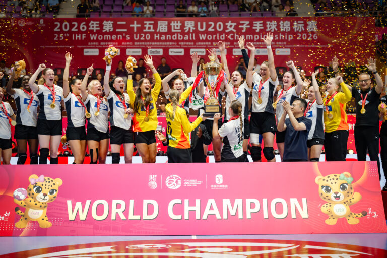 A team of athletes celebrates on a podium, holding a trophy and medals, with confetti falling and a banner reading "WORLD CHAMPION" below them.